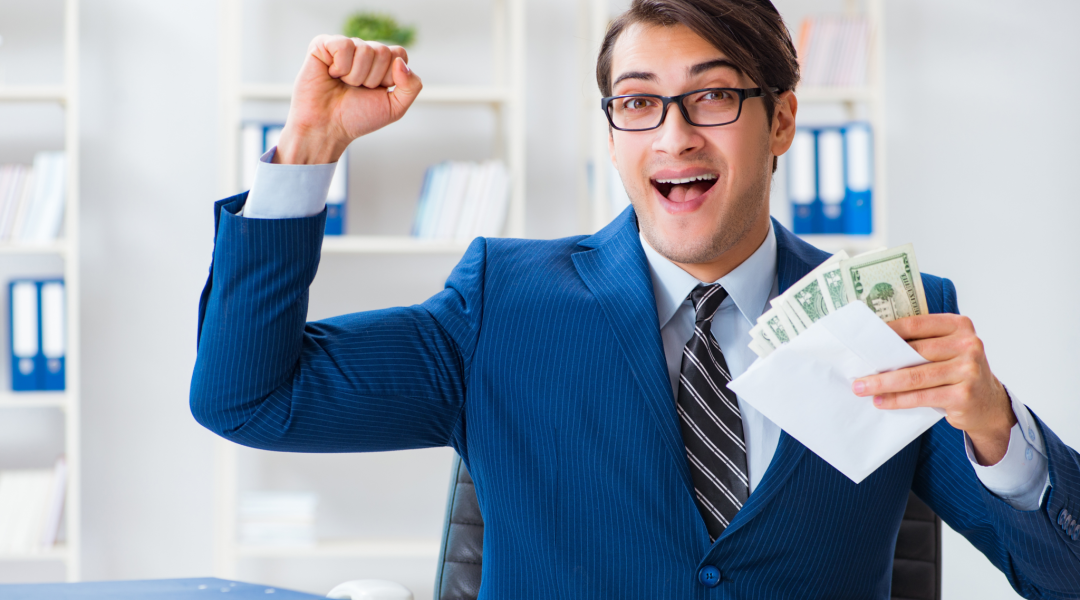 a man in a suit holding money in an envelope celebrating salary raise